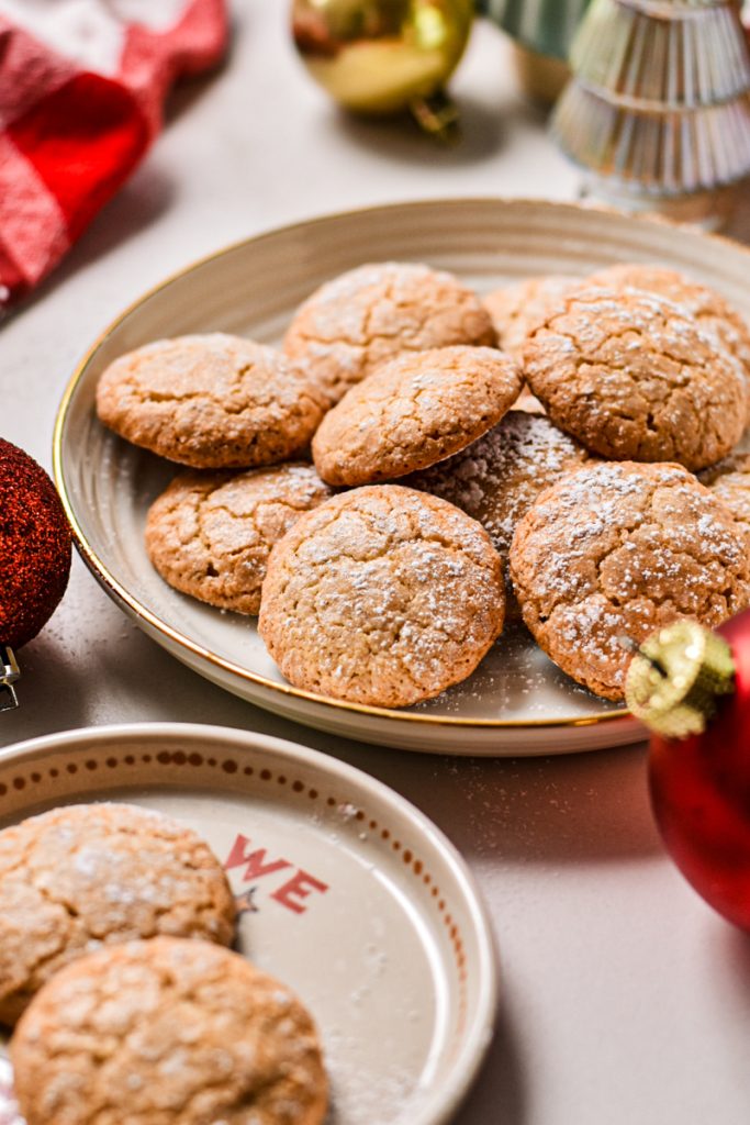Side view of macarons de Nancy on a plate dusted with powder sugar.